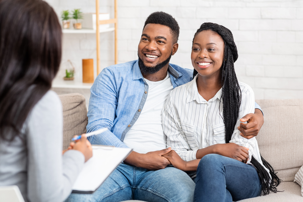 Happy,Black,Couple,Sitting,In,Counselor's,Office,After,Successful,Marital